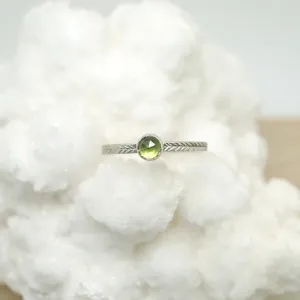 Peridot ring with hand-carved feather textures